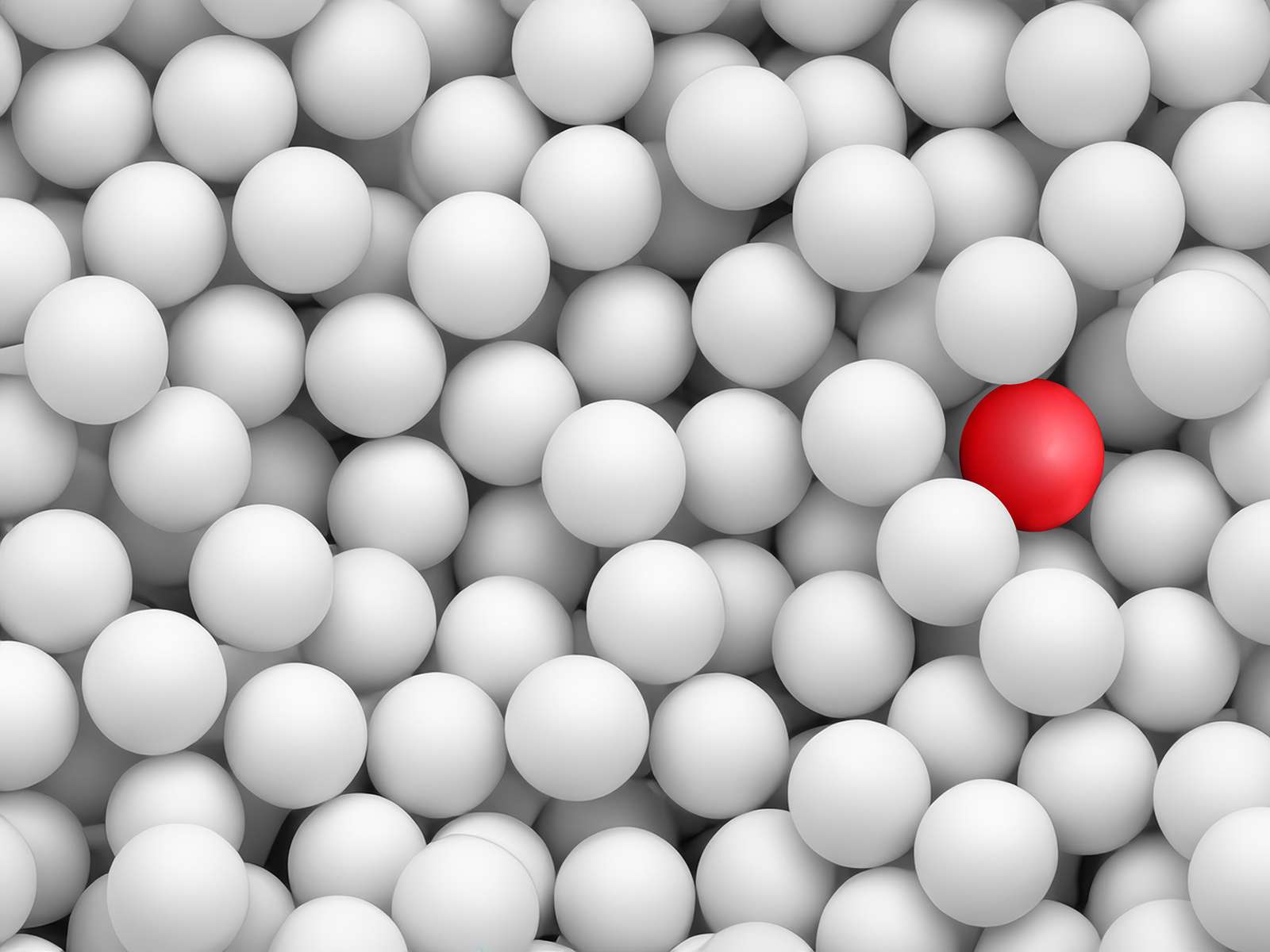 A single red ball among many white balls.